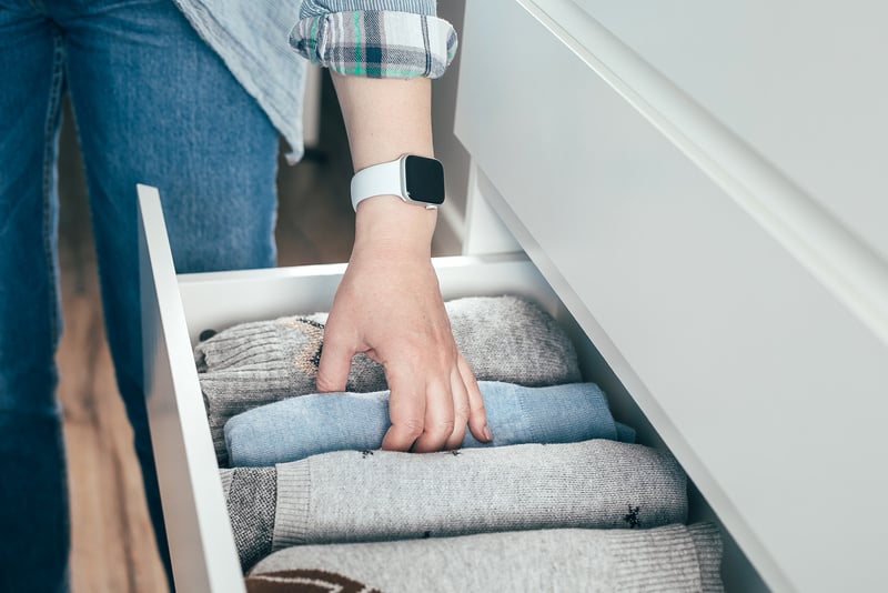 Person Organizing Stuff in Drawer